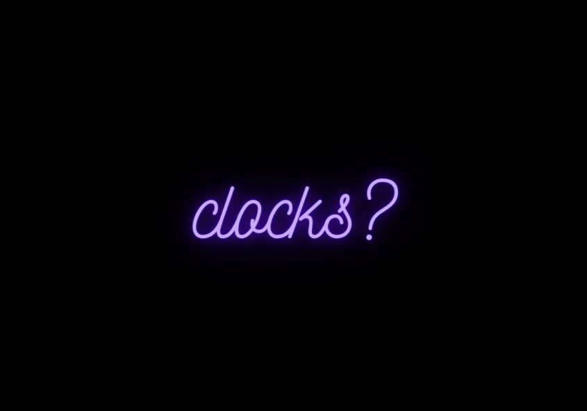 Glowing, neon purple text on a black background that says, "clocks?"