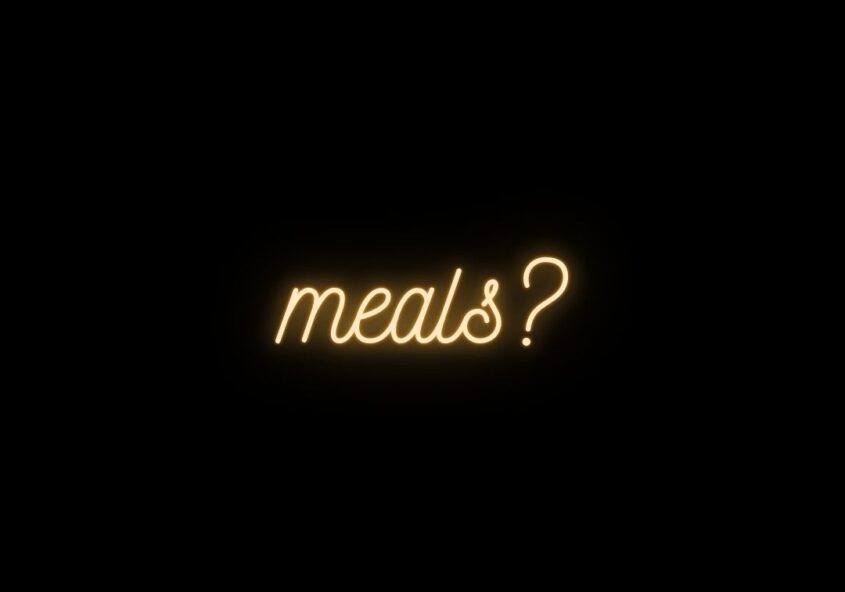 Glowing, neon amber text on a black background that says, "meals?"